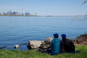 Couple sitting on the grass with views of Toronto cityscape