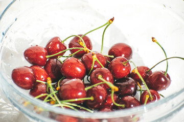 sweet cherries in a glass jar on the table. white background. Summer fruits. Seasonal fruits and vegetables. Vegetarian food. deliciously
