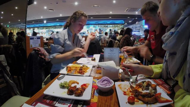 Family pairs eat in fast-food restaurant Todai. Timelapse