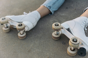 Close-up of a Woman’s Feet Wearing Quad Roller Skates on a Concrete Ground. Captivating shot of a...