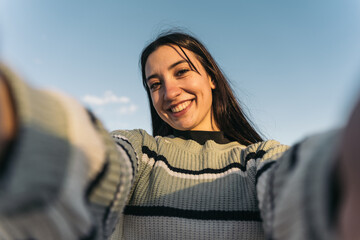 Joyful twentysomething Woman Capturing Selfie Moment at Urban Skate Park. Smiling young girl taking...