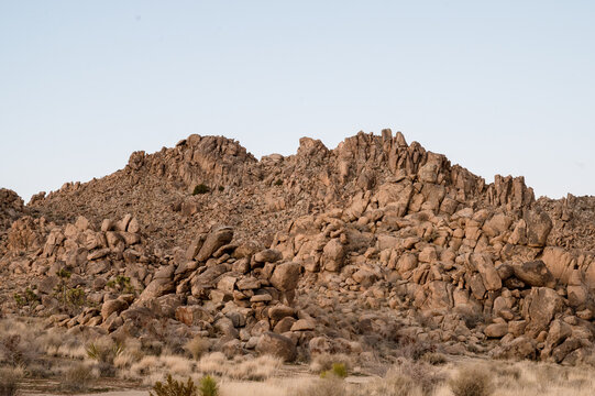 Color photo of desert boulders with on clear soft blue sky, american southwest