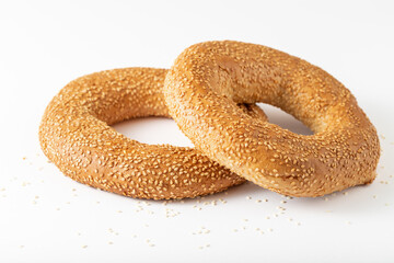 Two traditional turkish simit bagels with sesame seeds closeup on white