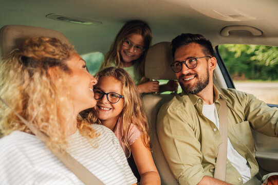 Happy caucasian family driving a new car or having a test drive in the city - Powered by Adobe