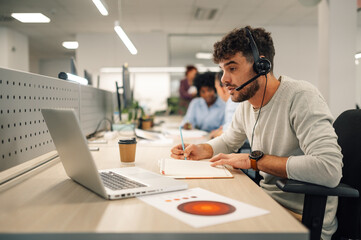 A virtual assistant is sitting at call center department and working.