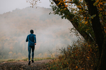 Runner Navigating Tranquil Paths Amidst Autumn's Foggy Embrace
