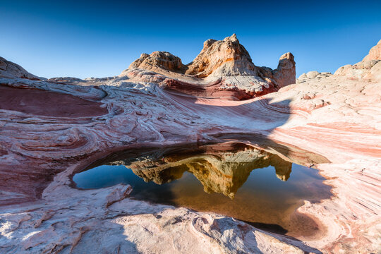 Rock formations reflected into water, White Pocket, Vermilion Cliffs National Monument, Arizona, United States