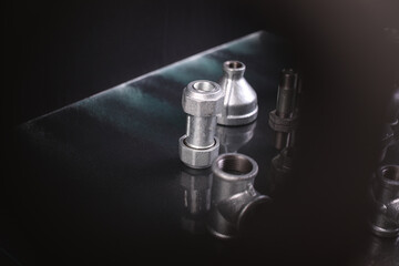 A set of metal and copper water pipe parts, a water wrench and pipe elbows, blue and red colors, black background, different shapes and different sizes