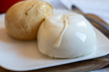 Tasty Italian food, small balls of white and smoked mozzarella soft cheese close up