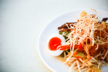 Food on a white plate placed in the right corner and space for text on a white background.