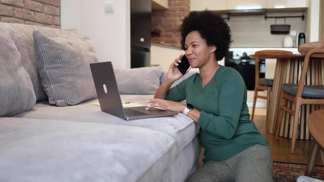 African American woman telephoning and working from home