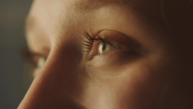 Close-up portrait of a young attractive woman opening her eyes and smiling