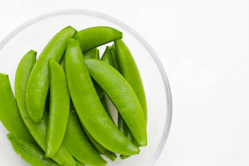 Fresh young green peas on white background.