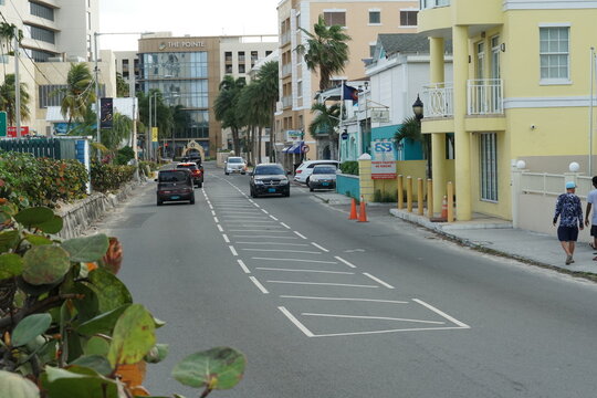 Nassau, Bahamas 12 03 2023: Street with walking people, cars, modern and old houses built in the typical architectural style of the colonial era in Nassau, Bahamas, on a Caribbean island. 