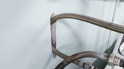 The friction of the metal flexible hose against the wall creates a hole in the wall.