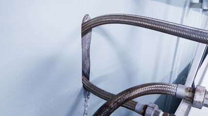 The friction of the metal flexible hose against the wall creates a hole in the wall.