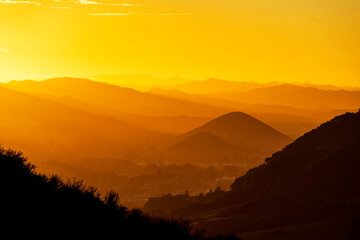 Sunrise, sunset with yellow light and mountains, hills