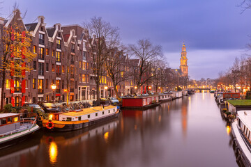 Fototapeta na wymiar Night city view of Amsterdam canal Prinsengracht with houseboats and Westerkerk church, Holland, Netherlands.