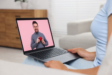 Fototapeta na wymiar Long distance love. Woman having video chat with her boyfriend via laptop at home, closeup