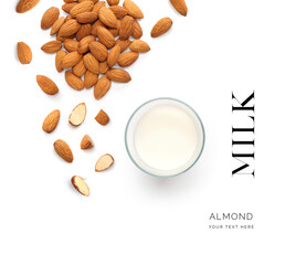 Creative layout made of almonds and a cup with almond milk on the white background. Flat lay. Food concept. Macro concept.