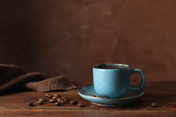 Turkish coffee. Freshly brewed beverage and beans on wooden table against brown background, space...