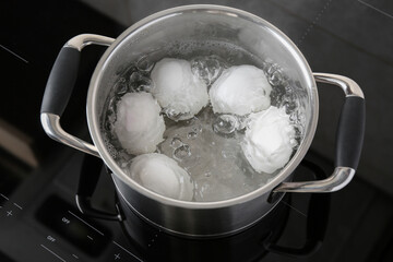 Fototapeta na wymiar Chicken eggs boiling in pot on electric stove, above view