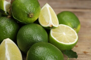 Pile of fresh limes on wooden table, closeup