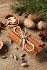 Different spices, nuts and fir branches on wooden table, above view
