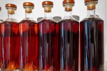 Different colours and ages of cognac spirits in bottles in distillery in Cognac white wine region,...