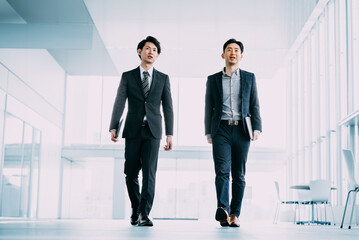 オフィスを歩く2人の男性ビジネスマン