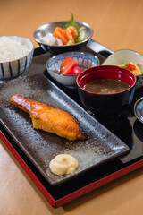 Salmon japanese food set on a black plate with soy sauce