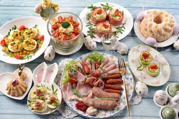 Top view of Easter breakfast with a plate of cold cuts, deviled eggs and vegetable salads