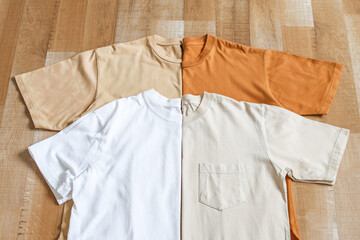 Collection of brown color mockup t-shirt variant folded in half and side by side on wooden floor