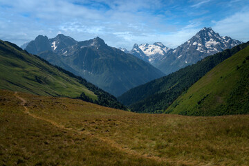 View of the peaks of the North Caucasus mountains and the trail to Smirnov Peak near the Arkhyz ski resort on a sunny summer day, Karachay-Cherkessia, Russia