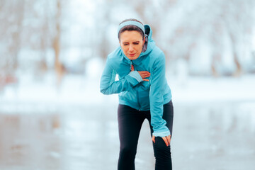 Tired Woman Having Chest Pains After Running on a Winter Day. Exhausted jogger experiencing an...