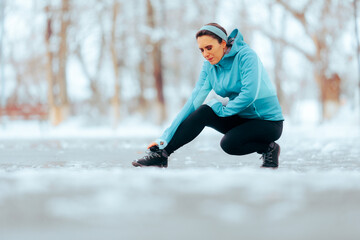 Sad Woman Hurting her Ankle During a Running Session in Wintertime. Unhappy runner suffering a accident in training routine
