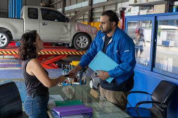 A very attractive women get her car back at the counter of the tire and car service shaking hand...