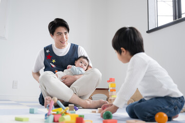 保育園などで遊ぶ幼児と男子保育士と赤ちゃんのイメージ