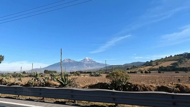 4k video of Sierra Negra volcano and Pico de Orizaba as seen from a moving car on the road. Mexico, landscape