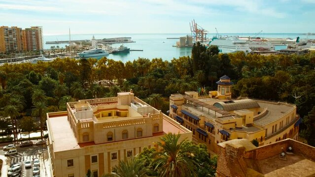 Establishing shot of Malaga, Andalucia, Spain captures the bustling sea port and government buildings with a vibrant city backdrop