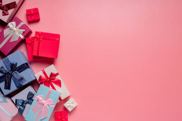 Top view photo of valentine's day decorations giftbox with silk ribbon bow on isolated pastel pink background with copyspace, concept Valentine's Day.