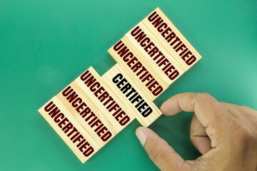 wooden arrangement with the words UNCERTIFIED and CERTIFIED. concept of checkup or checklist