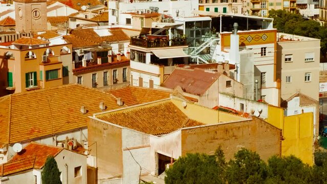 Establishing shot of Malaga, Andalucia, Spain captures the bustling sea port and government buildings with a vibrant city backdrop