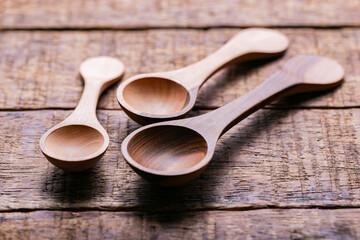 Three wooden measuring spoons on old table, close-up