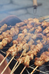 The process of grilling chicken satay on a traditional stove