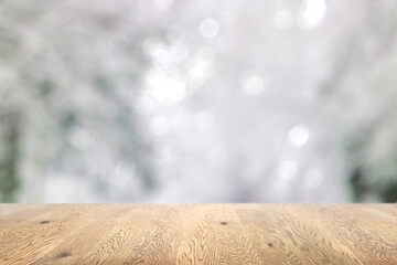 木目のある木製のテーブル越しに見えるボケた背景、奥行きのある背景、雪景色の背景画像