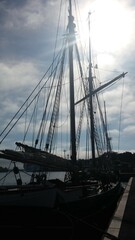 Obraz premium Silhouette of a sailboat against the sunny sky