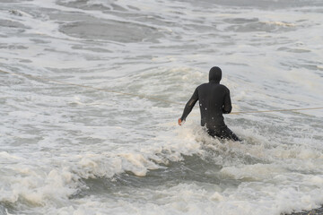 Man in wetsuit snorkeling into the sea water