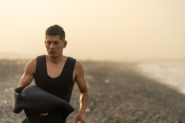 Fototapeta na wymiar Fisherman taking off the wetsuit on the beach