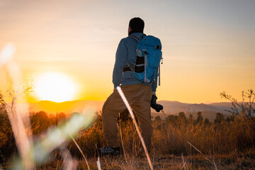 photographer, with camera and backpack, immortalizes the spectacular sunrise
